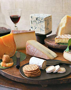Assorted cheeses paired with fruit and crackers.